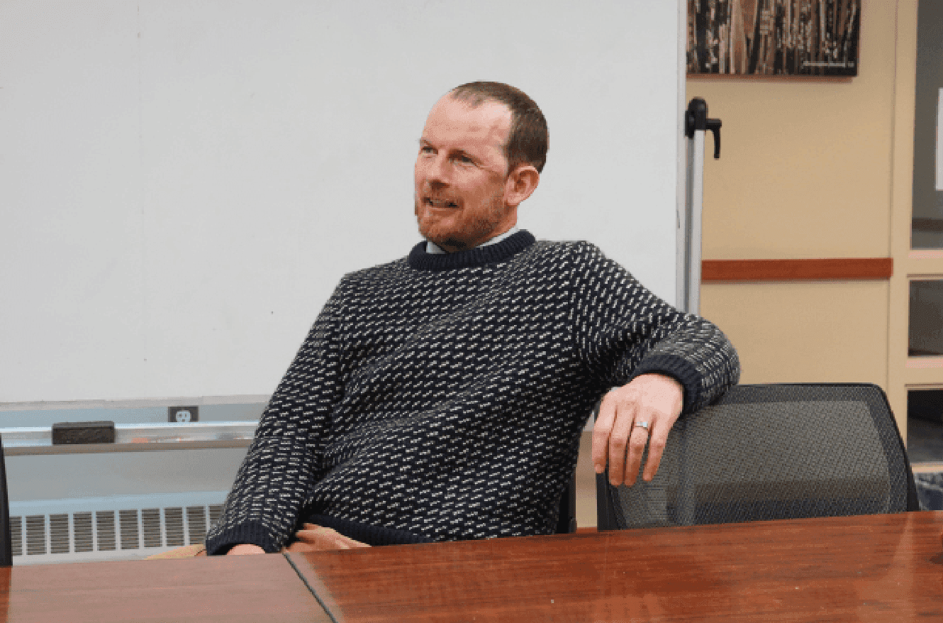 “I was walking down the street and…”
You would probably expect a story, but if Mr. Whittemore is your math teacher, you know that he likes to frame his classes in the form of a narrative. If you hear his iconic sentence, you know he is moving on to the next homework problem. Surrounded by chattering students in EPAC 319, Instructor in Mathematics Tim Whittemore is seated at the head of the table.